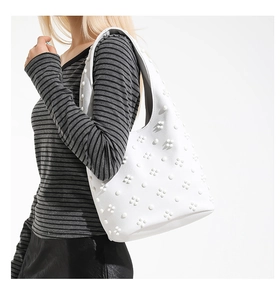 Détail du sac cabas blanc en cuir avec appliques florales et trèfles en relief 3D