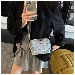 Detail view of light blue quilted mini box bag with silver chain strap and metal frame