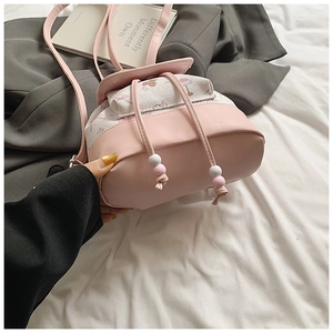 Detailed view of small pink and white bucket bag with drawstring and floral print