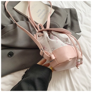 Detail of pink floral bucket backpack showing drawstring closure and silver metal hardware