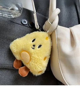 Close-up of a bright yellow plush charm attached to a white leather handbag