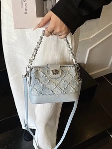 Light blue quilted denim box bag with silver chain and adjustable shoulder strap