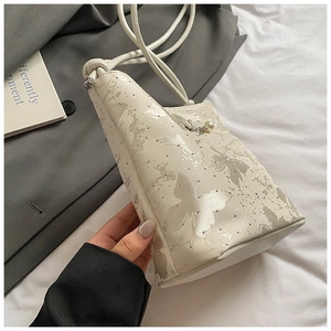 Détail du sac blanc à nœud avec imprimé papillon, perles argentées et fine bandoulière