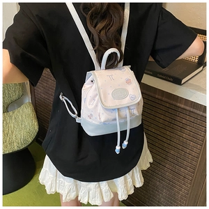 Detailed back view of mini pink and blue backpack with cute bear and bow patterns