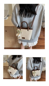 Detail of straw mini tote bag with brown leather handles and a white tulip charm