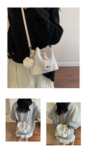 Detail of laser texture bucket bag with adjustable strap and plush monster charm