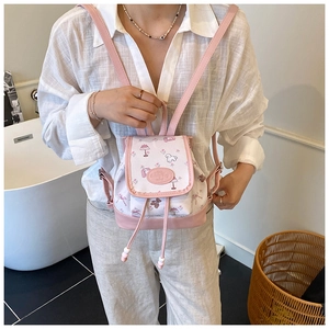 Detailed view of pink cartoon mini backpack with heart leather patch and drawstring closure