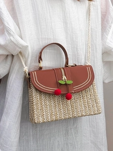 Handwoven straw box bag with brown leather flap and cherry charm for beach vacation