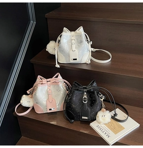 Three sequined drawstring bucket bags in white, pink, and black with cute sheep pendants