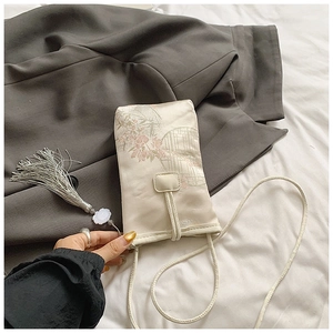 Detail of silk phone bag with peach blossom embroidery and long grey tassel ornament
