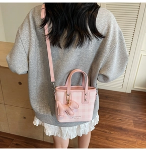 Detail of pink plaid tote bag with cute bear charm and adjustable shoulder strap
