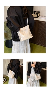 Detail of off-white bucket bag featuring bow tie decor and delicate pearl pendant