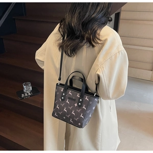 Fashionable small crossbody tote bag with deer print on a beige trench coat model