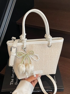 Elegant off-white woven bucket bag with leather handles and pearl tulip charm