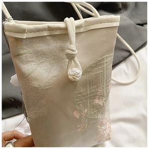 Detail of embroidered plum blossoms and silk texture on a Chinese style crossbody phone bag