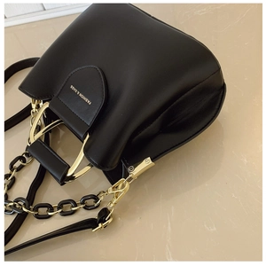 Detail of black bucket bag featuring golden hardware and Fashion & Bags text logo