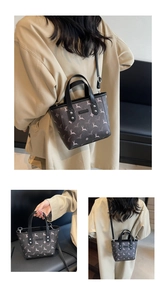 Detail view of small bucket bag with white deer print and detachable shoulder strap
