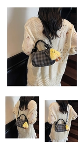 Close-up of checkered crossbody bag with pleated opening and yellow chick charm detail