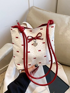 Sac seau blanc avec motif nœud rouge et pendentif cœur en situation réelle