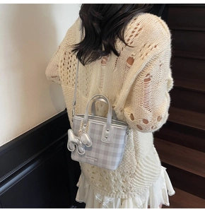 Detail of silver plaid mini tote bag with cute dog charm and adjustable shoulder strap