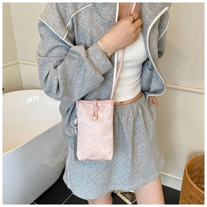 Detail of pink brocade phone bag with grey tassel and crossbody strap in retro style