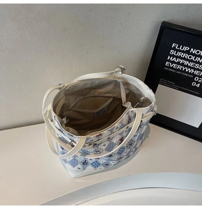 Detailed interior of a printed tote bag showing lining, zipper pocket, and metal hook