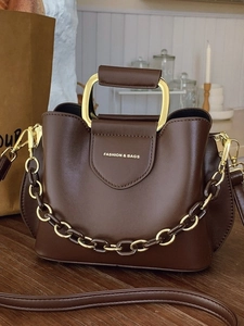 Vintage dark brown bucket bag with gold metal handle and decorative chain strap