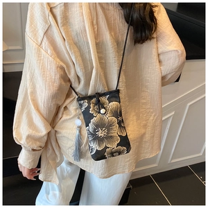 Detail of Chinese style phone bag featuring golden floral embroidery and beaded tassels