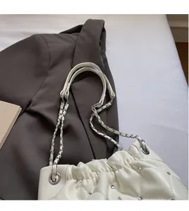 Détail du sac blanc matelassé avec strass brillants et bandoulière en chaîne argentée