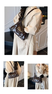 Détail du sac à bandoulière en cuir verni marron foncé avec boucle dorée en croissant
