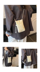 Detail of bamboo embroidery and silk tassel on the cream crossbody phone bag