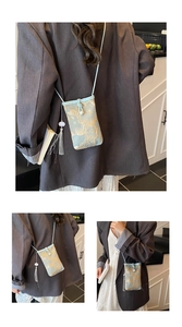 Detail of light blue embroidered crossbody phone bag with gold flowers and tassel charm