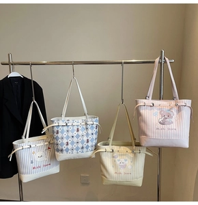 Detail view of assorted canvas tote bags featuring cartoon characters and striped patterns