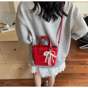 Petit sac fourre-tout rouge avec nœud en dentelle et pampille de perles porté en bandoulière