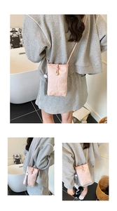 Detail of pink jacquard phone bag with silk texture, pearl clasp and long grey tassel