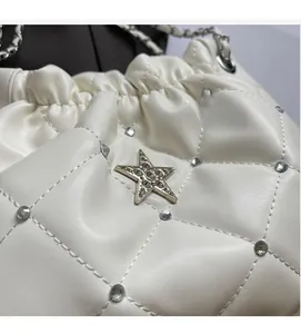 Détail de sac en cuir blanc matelassé avec ferrures en étoile et accents de diamants