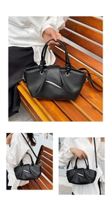 Detail of black lychee grain leather bucket bag with silver buckle on a wooden bench