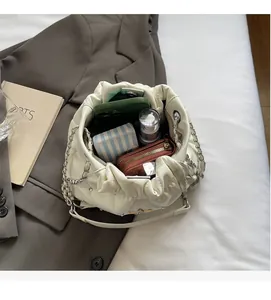 Détail du sac seau en cuir matelassé blanc montrant sa grande capacité de rangement