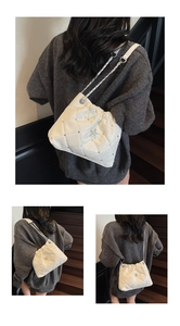 Détail du sac à bandoulière matelassé blanc avec étoile argentée et bandoulière chaîne