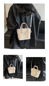 Detail of cream mini bucket bag with pearl lace bow and adjustable shoulder strap