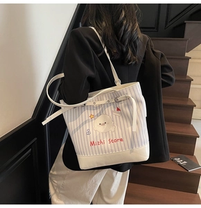 Detail of blue striped canvas tote bag with seal prints and adjustable white strap