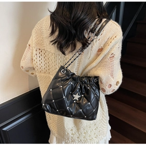 Détail du sac matelassé noir avec strass argentés et emblème étoile et bandoulière chaîne