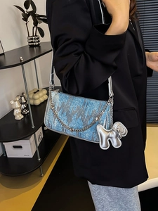 Blue denim underarm bag with silver sequins and poodle charm shown on model