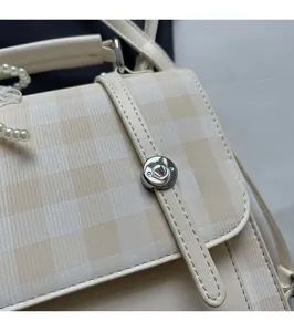 Detail of vintage plaid handbag featuring premium stitching and delicate lace trim