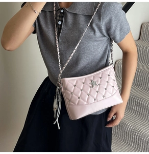 Detail of pink quilted handbag with star badge and silver studded rivets on leather