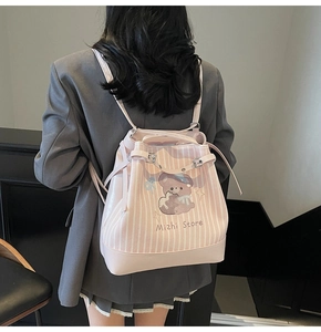 Pink and white striped drawstring backpack featuring a purple cartoon bear illustration