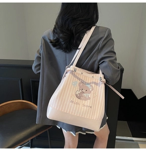 Detail of pink striped tote bag with cute cartoon bear and metallic strap buckle