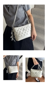 Detail view of cream quilted shoulder bag with star rivets and chain strap accents