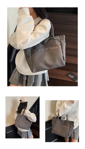 Detail view of large grey canvas tote bag with orange embroidery and side pocket