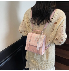 Close-up of pink plaid backpack with lace pearl bow and metal twist lock on a model